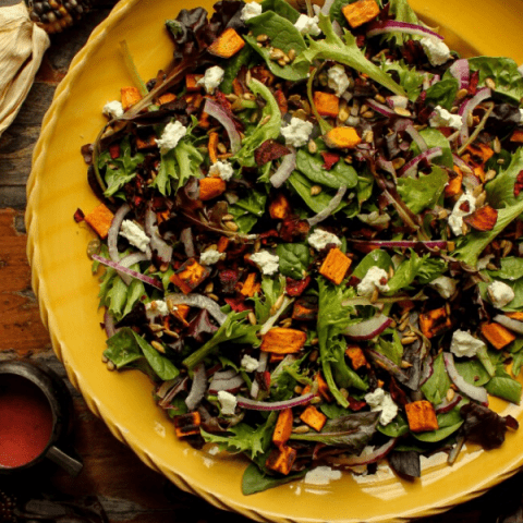 Large bowl of salad shot from above with fall decor.