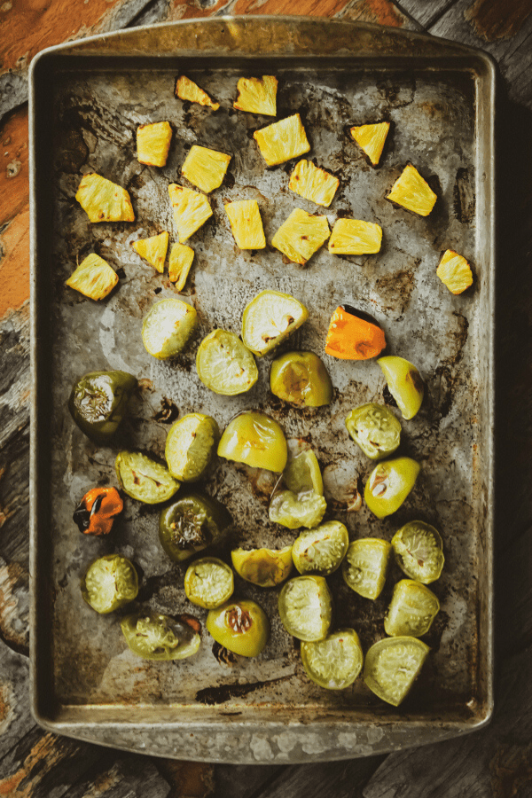 roasted pineapple, habanero, and tomatillos on a baking sheet shot from above
