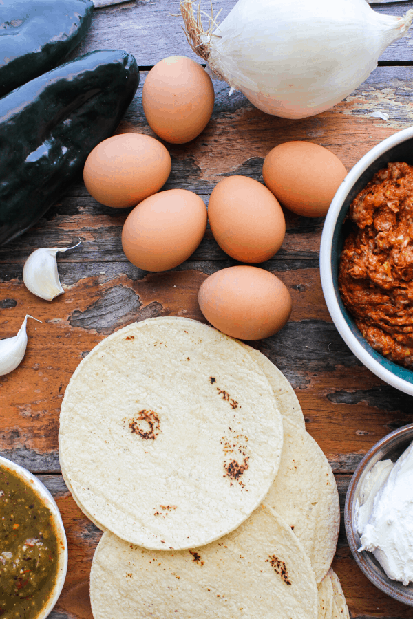 ingredients for huevos rancheros casserole on distressed wood surface from above 