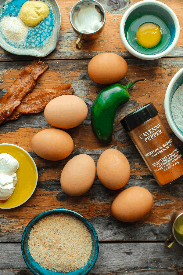 ingredients for deep fried jalapeno popper deviled eggs on distressed wood surface from above 