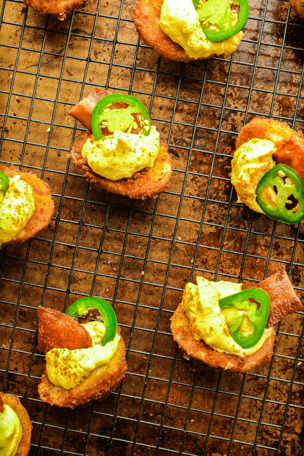 deep fried jalapeno popper deviled eggs on wire cooling rack atop sheet pan from above 