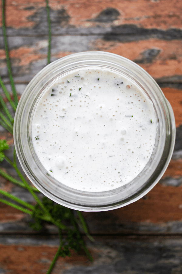garlic ranch in jar with sprigs of parsley from above 