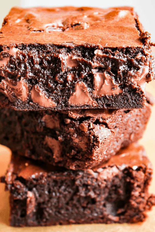 three fudgy double chocolate brownies stacked atop one another 