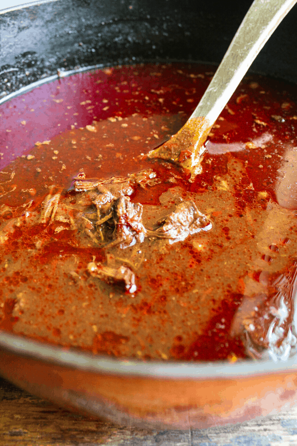 beef birria in dutch oven with wooden spoon 