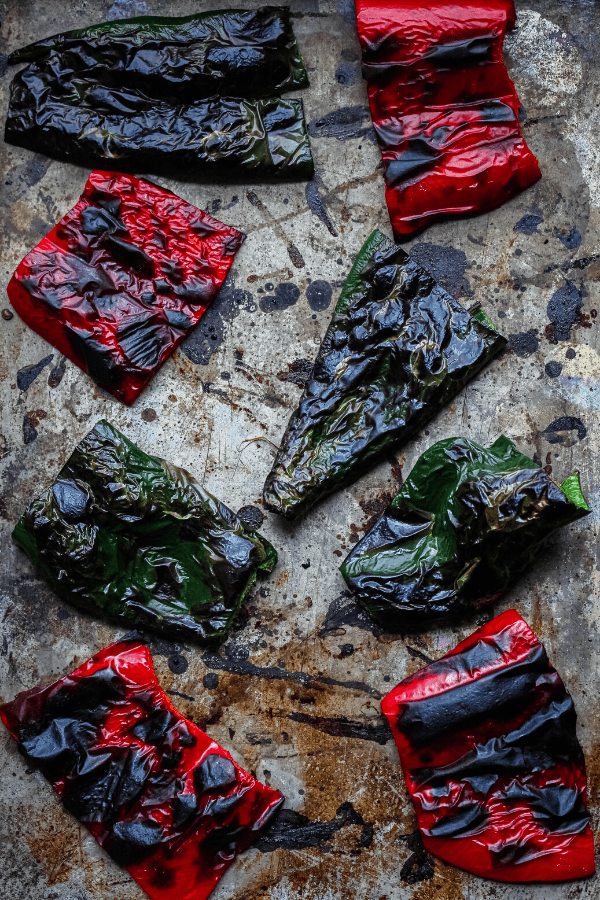 roasted poblano and red bell peppers on a baking sheet shot from above