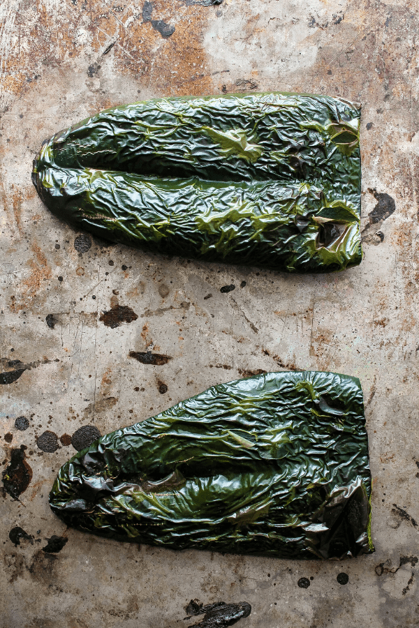 two roasted poblano slices on a baking sheet shot from above 