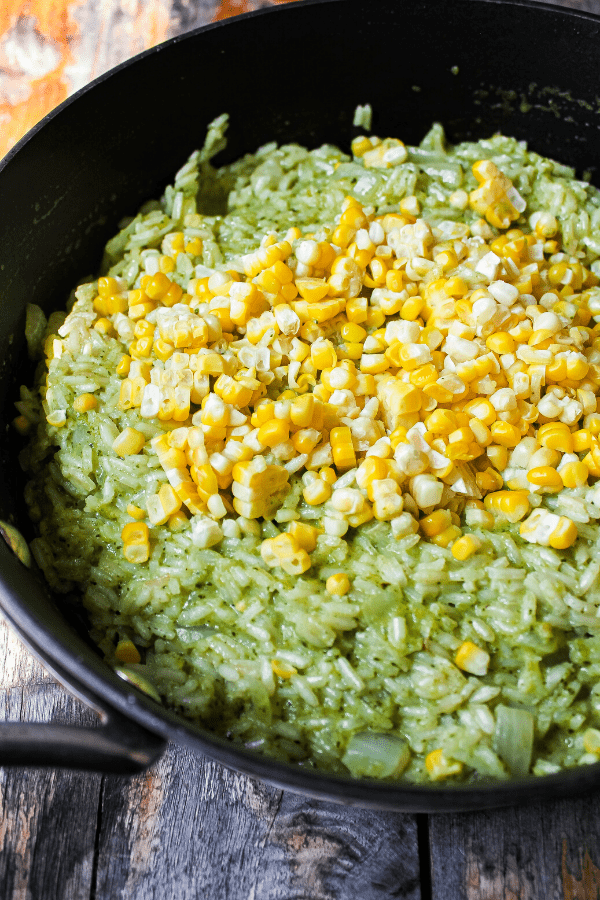 creamy poblano rice in sauté pan topped with corn