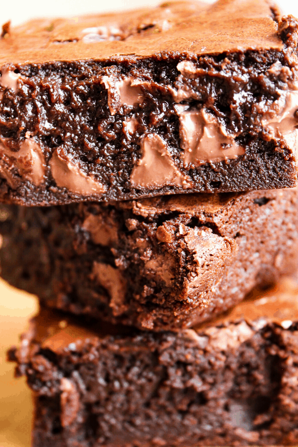close-up of three fudgy double chocolate brownies stacked atop one another 