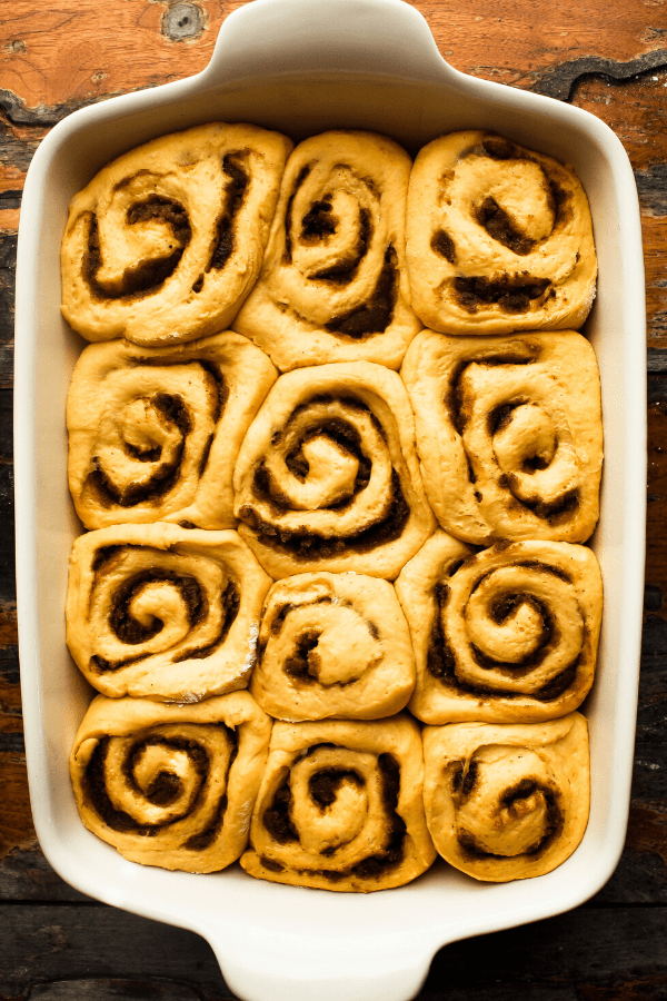 pumpkin cinnamon rolls with chai spice in pan after rising 