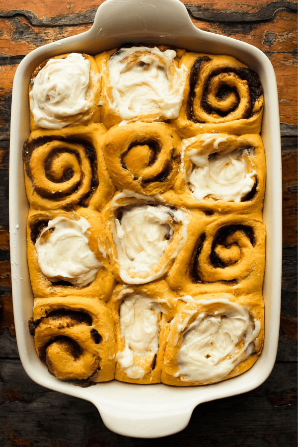 pumpkin cinnamon rolls with chai spice in white pan from above