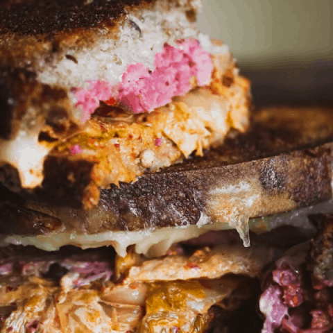 close-up side view of two stacks of kimchi reuben stacked atop one another