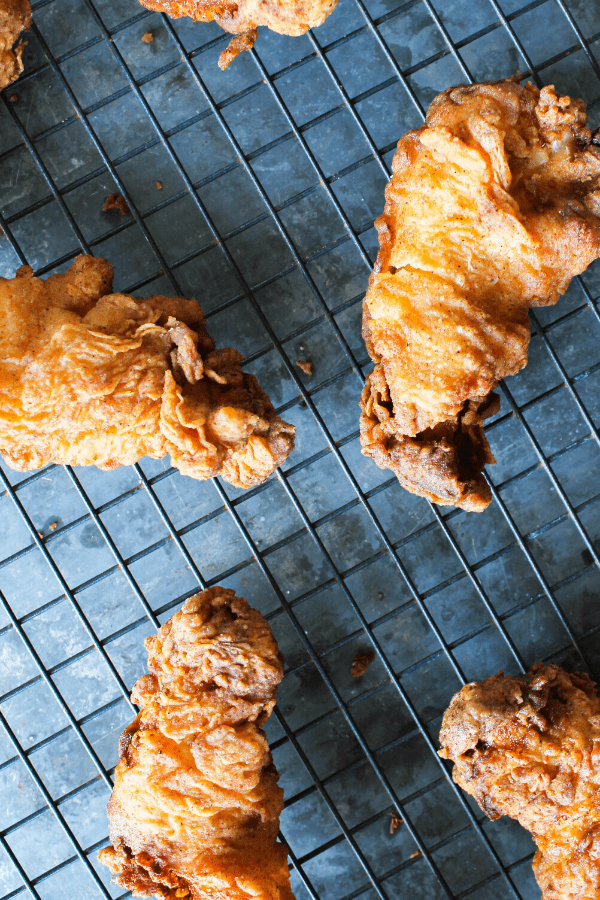 Pickle-brined fried chicken tenders on metal cooling rack shot from above. 