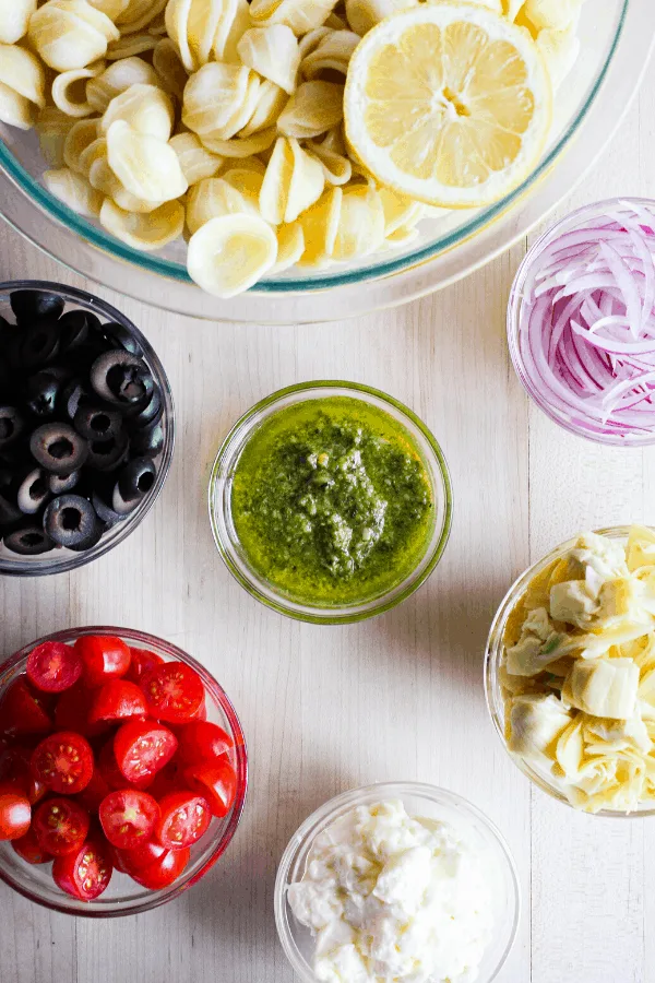 Ingredients for pasta salad in bowls shot from above.