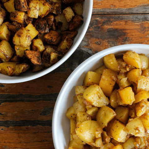 One bowl of roasted French onion potatoes and a second bowl of grilled French onion potatoes shot from above.