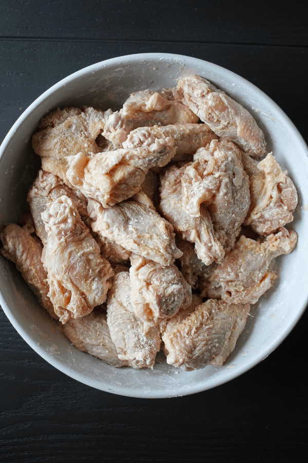 Top down shot of chicken wings coated in cornstarch. 