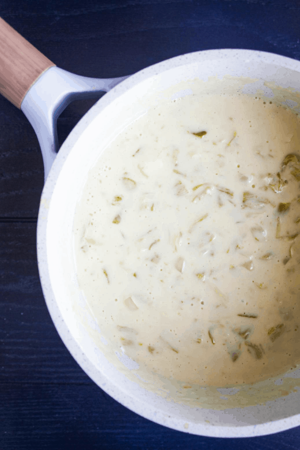 Top down shot of small saucepan containing hatch chile queso. 