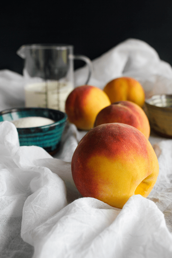 Peaches and cream ingredients on a white surface.