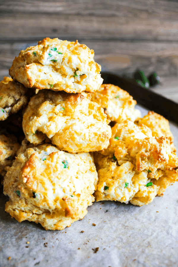Close-up of stack of jalapeno cheddar drop biscuits with jalapenos in the background. 