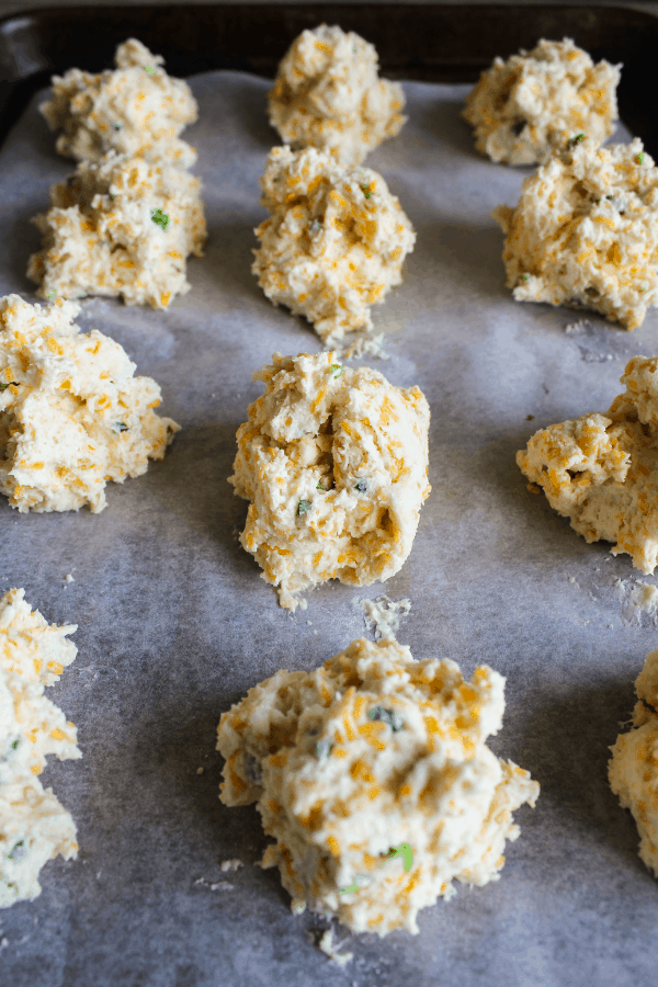 Front shot of uncooked biscuits on a baking sheet. 