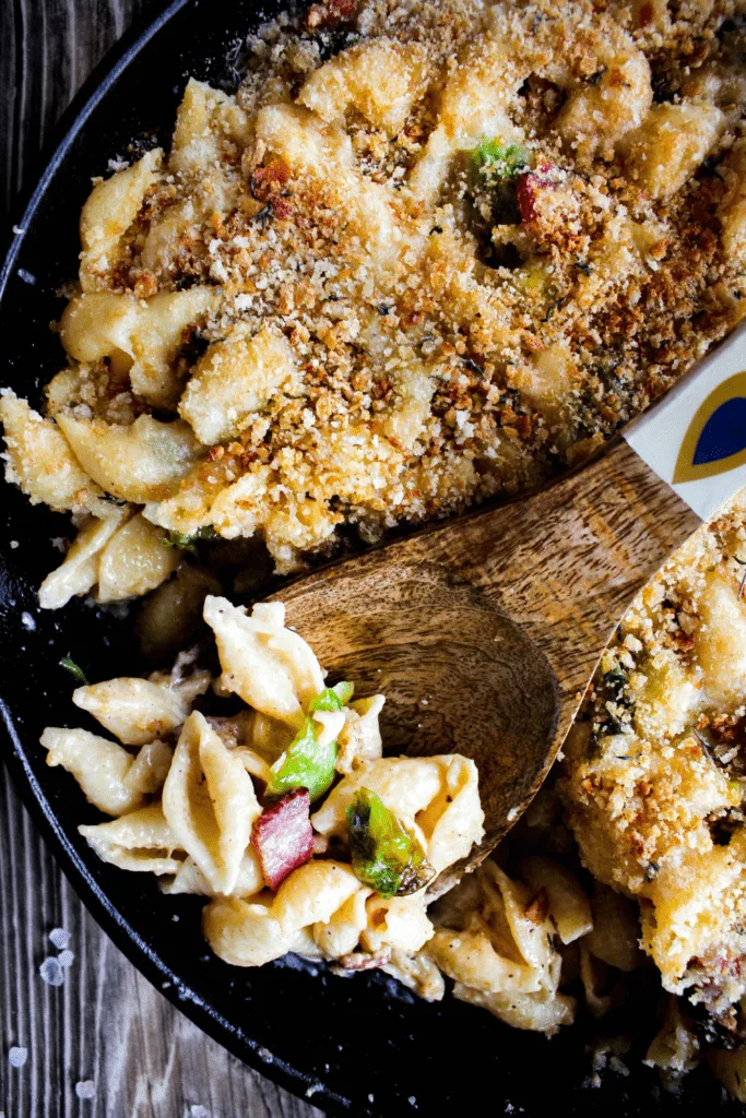 Top down shot of pan of mac and cheese with decorative wooden spoonful of mac.