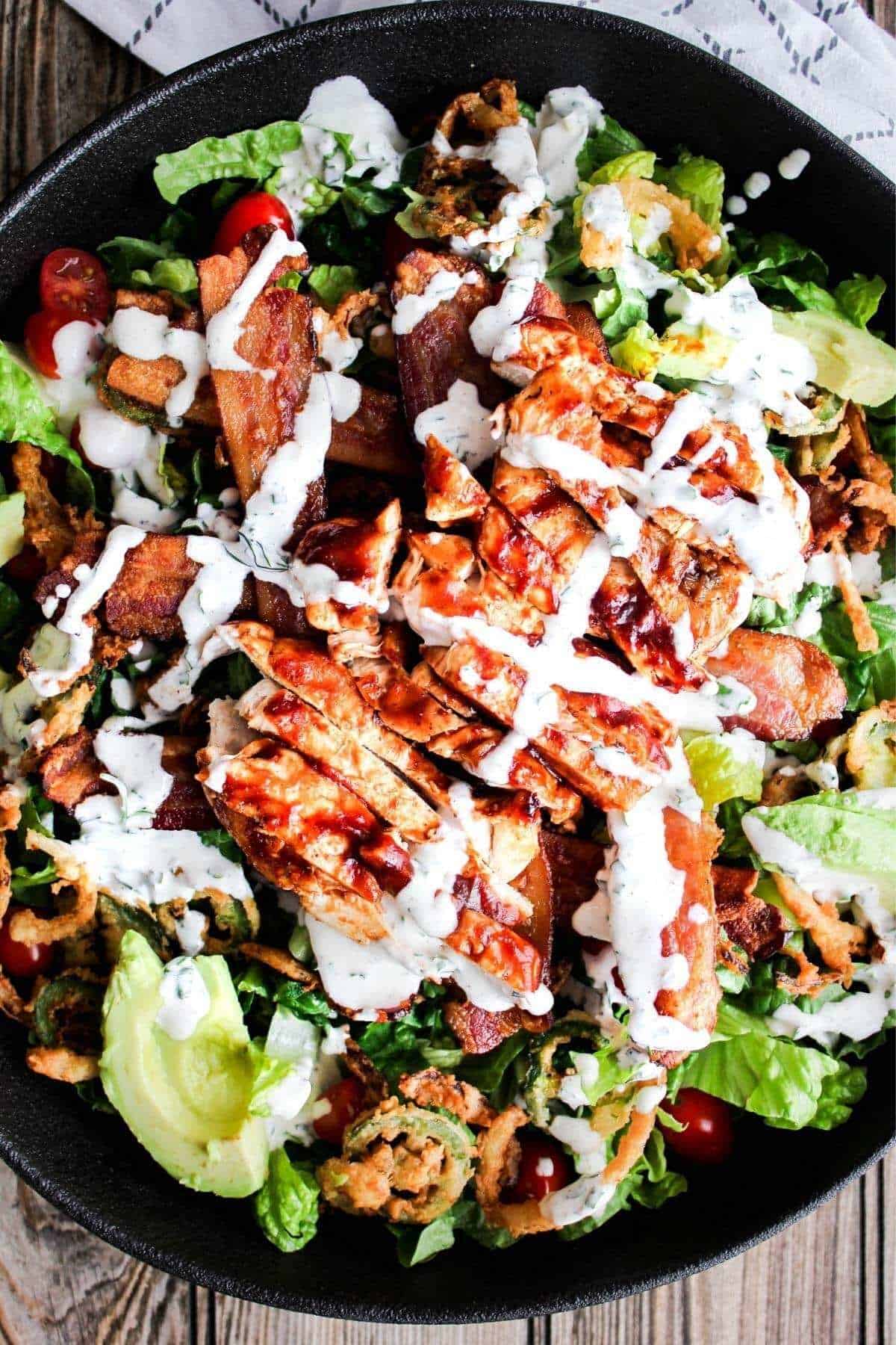 Top down shot of bowl of bbq chicken bacon ranch salad.