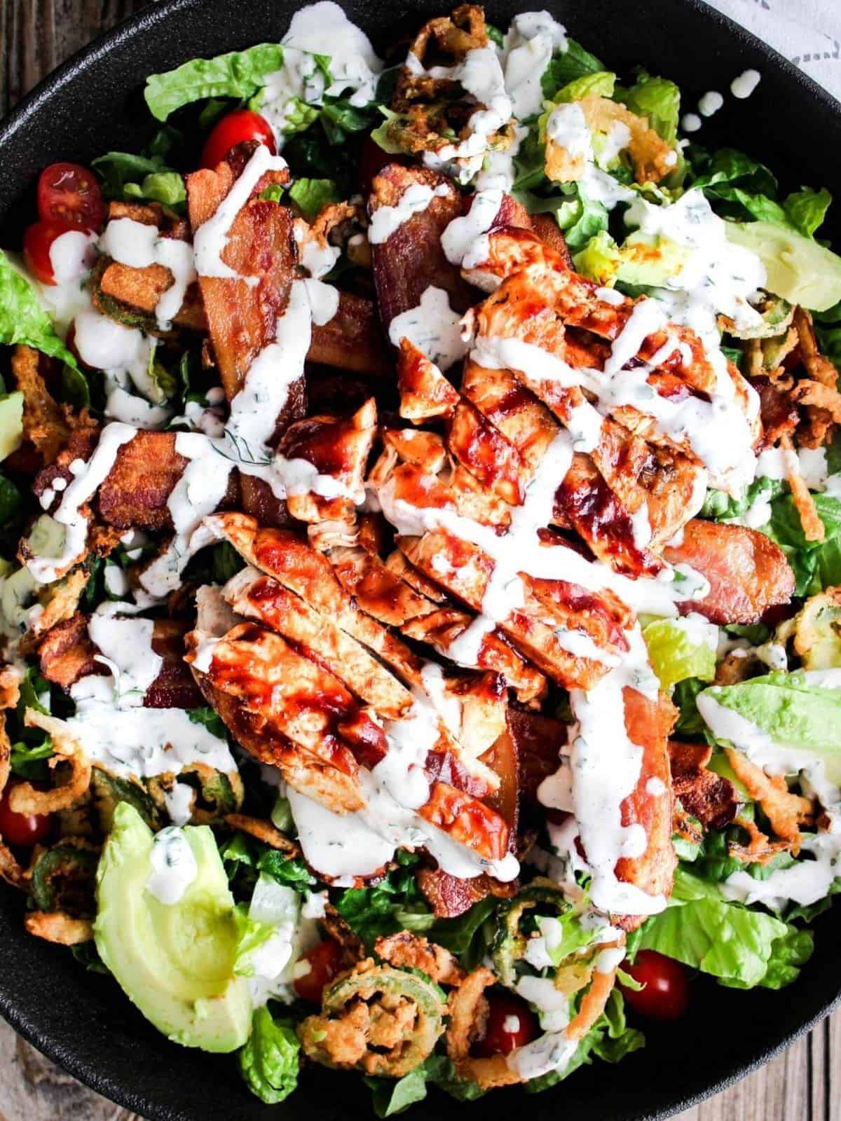 Top down shot of bowl of bbq chicken bacon ranch salad.