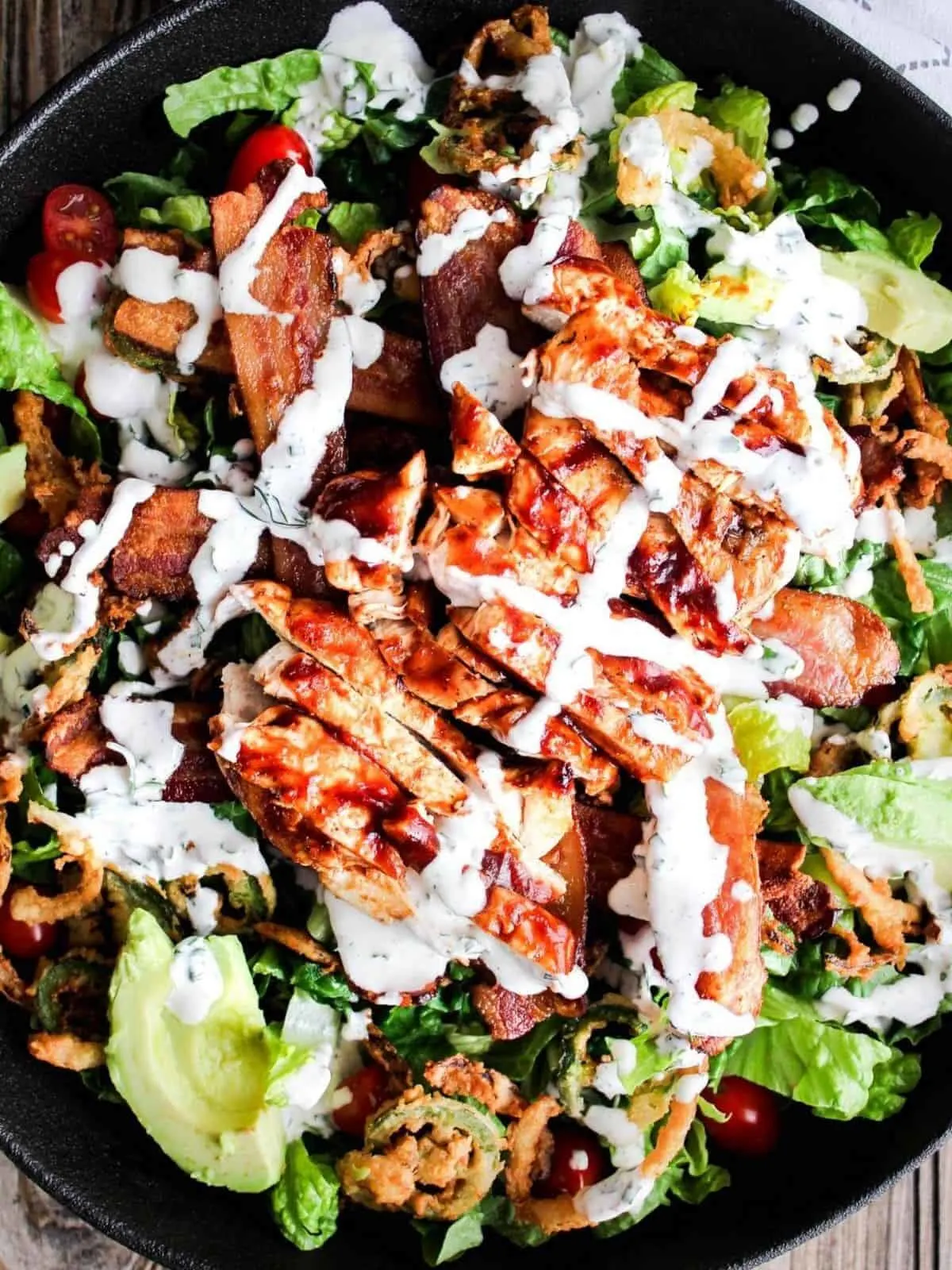 Top down shot of bowl of bbq chicken bacon ranch salad.