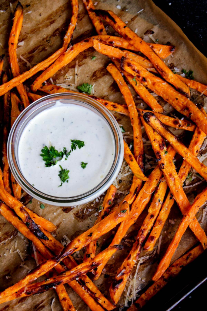 Sweet potato fries and a small bowl of ranch dressing.