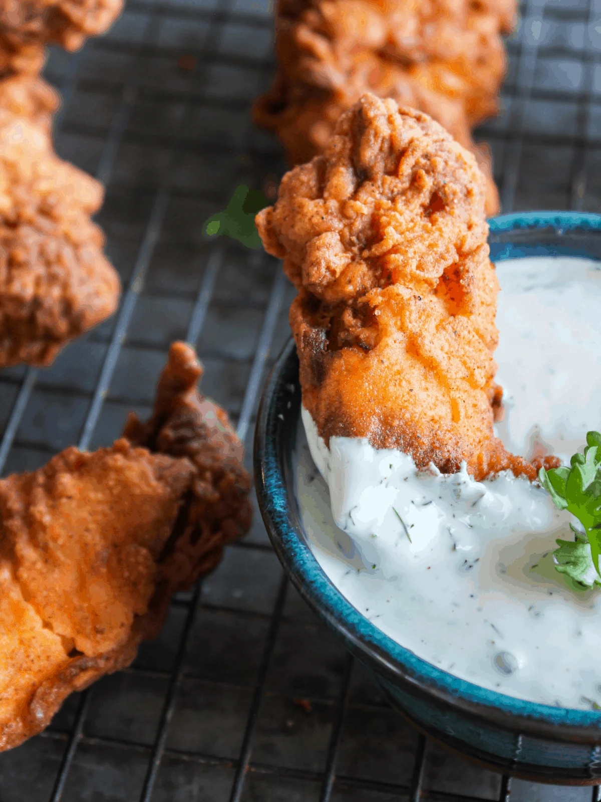 Chicken tender dipped in bowl of ranch.