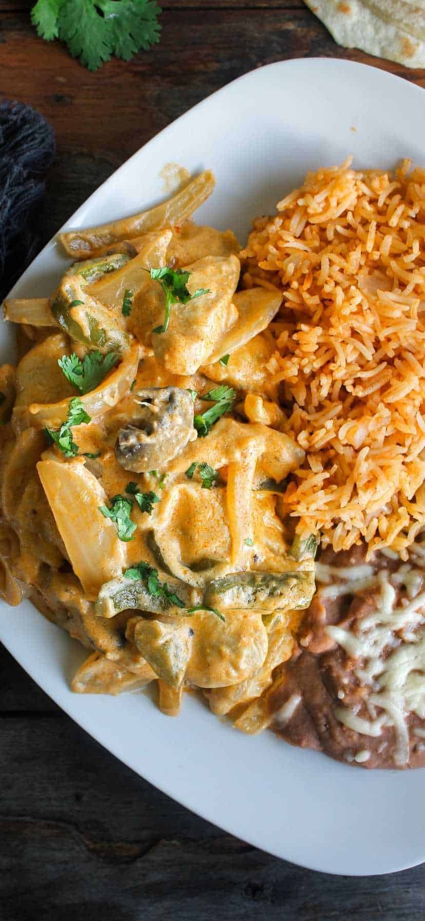 Plate of pollo a la crema with a side of rice and beans.