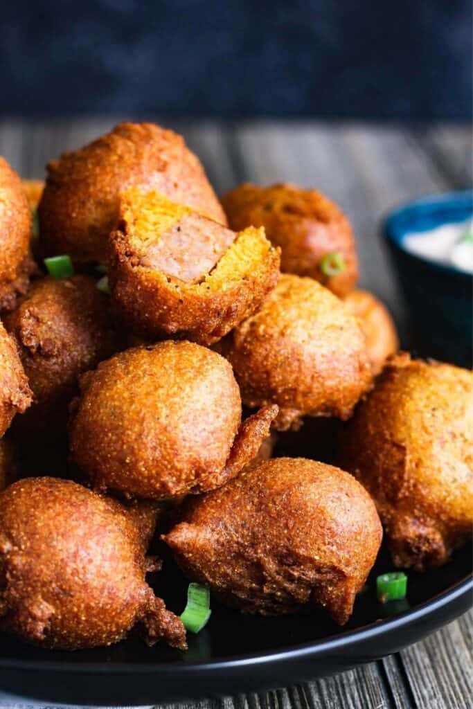 Stack of corn dog bites on a plate.