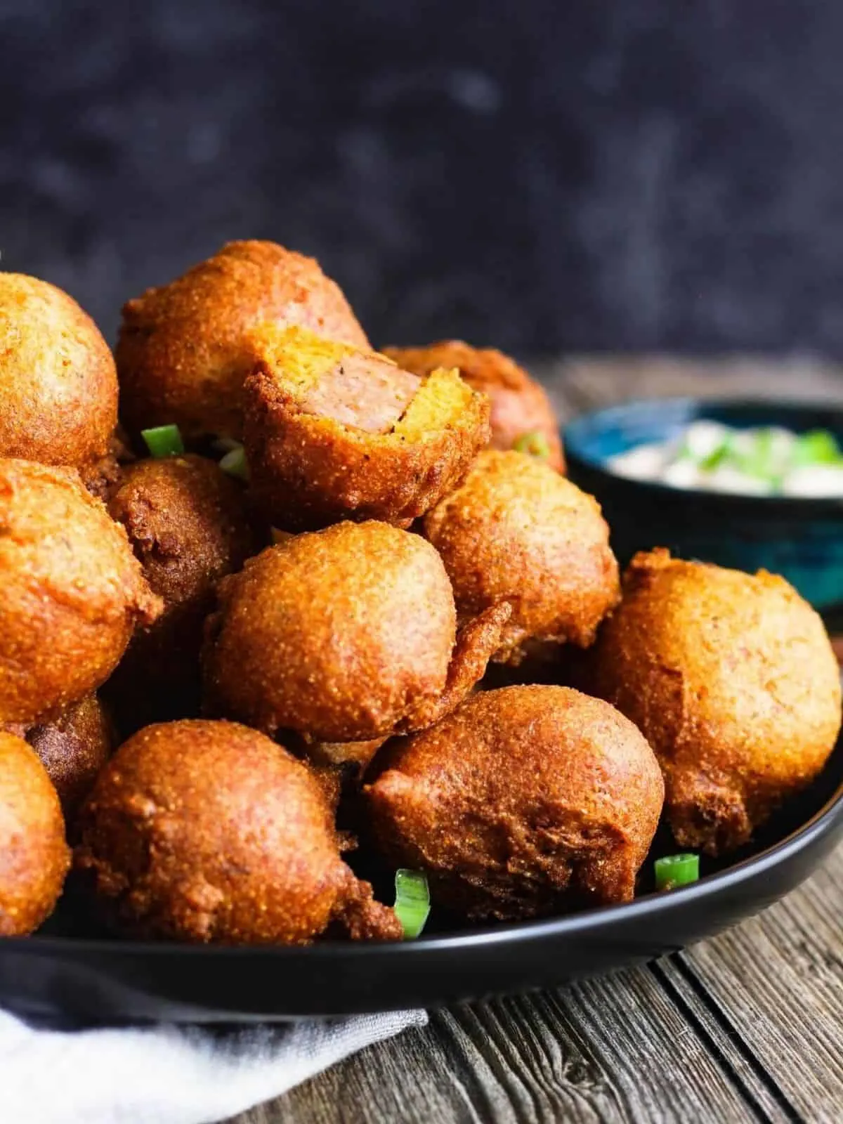 Plate of hush puppy corn dog bites with bowl of sauce.