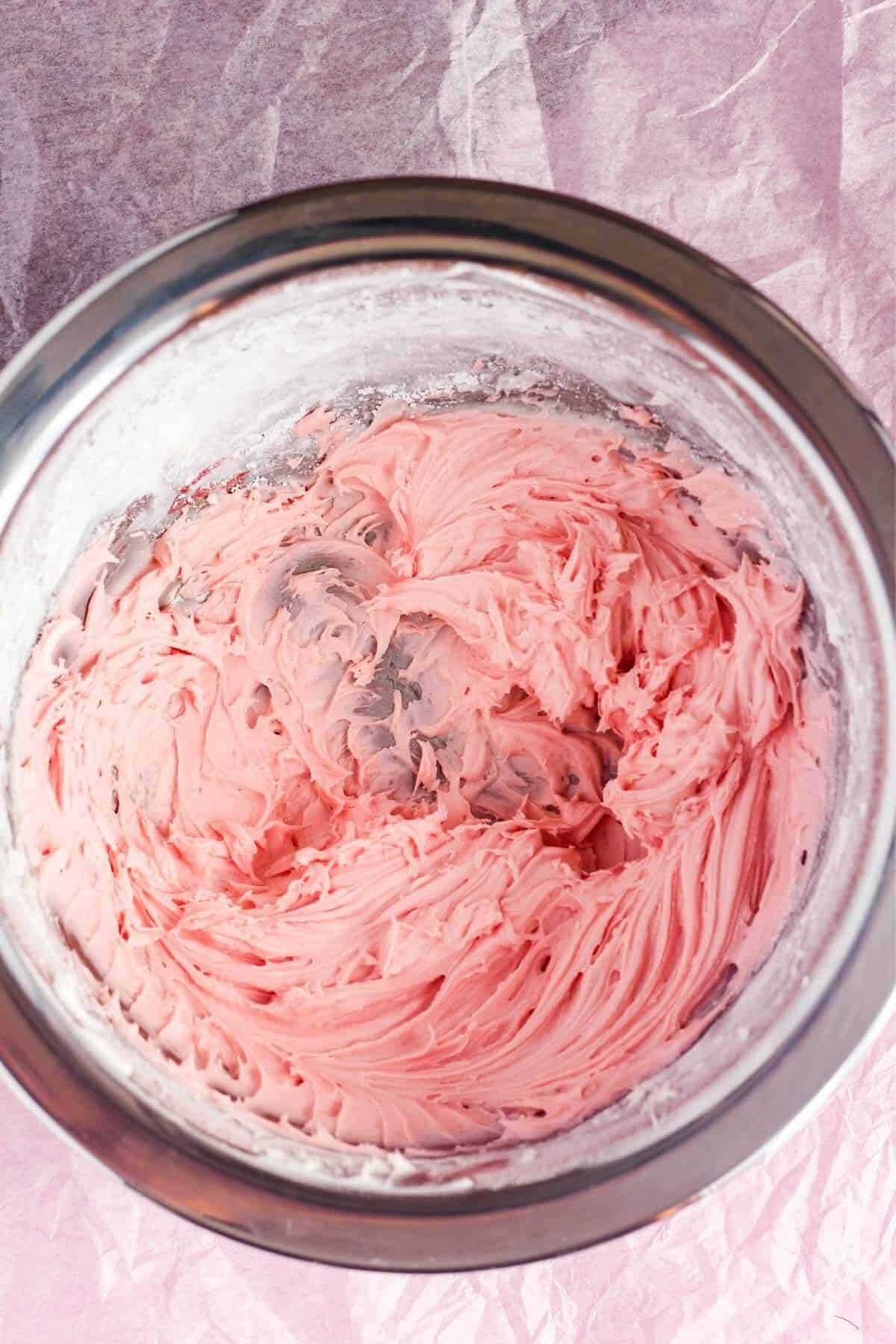 Strawberry buttercream frosting in a bowl.