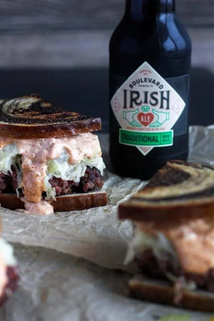 Multiple burgers with a beer.