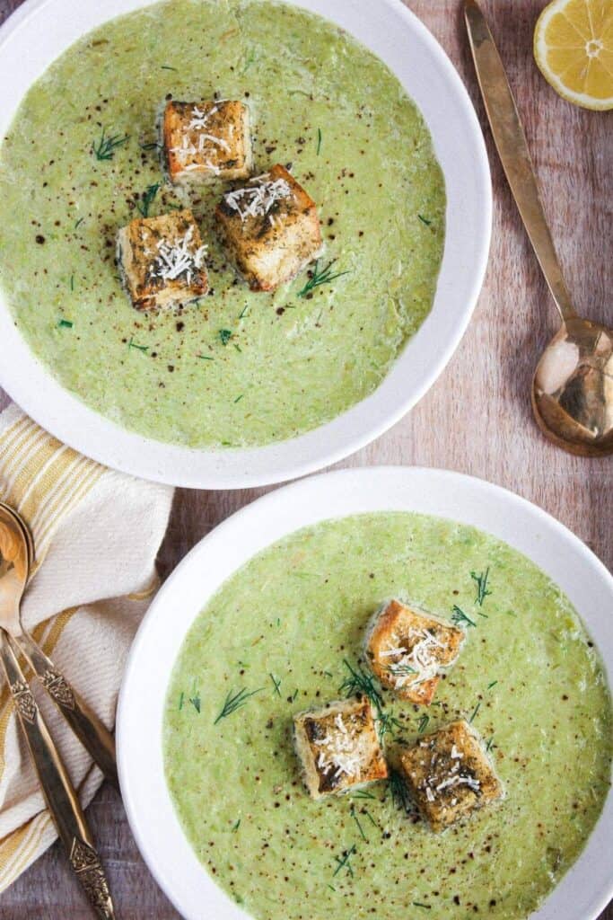 Close up of two bowls of asparagus leek soup.