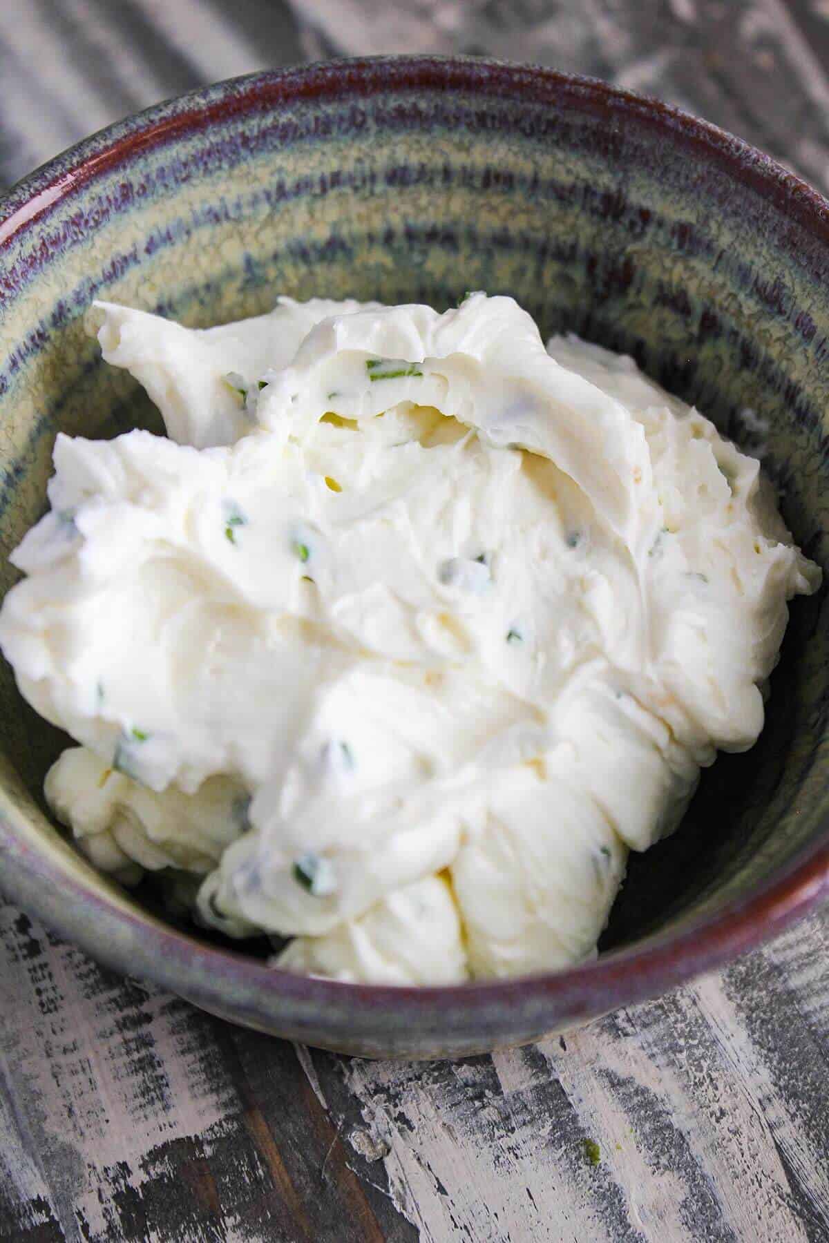 Chive cream cheese in a small bowl.