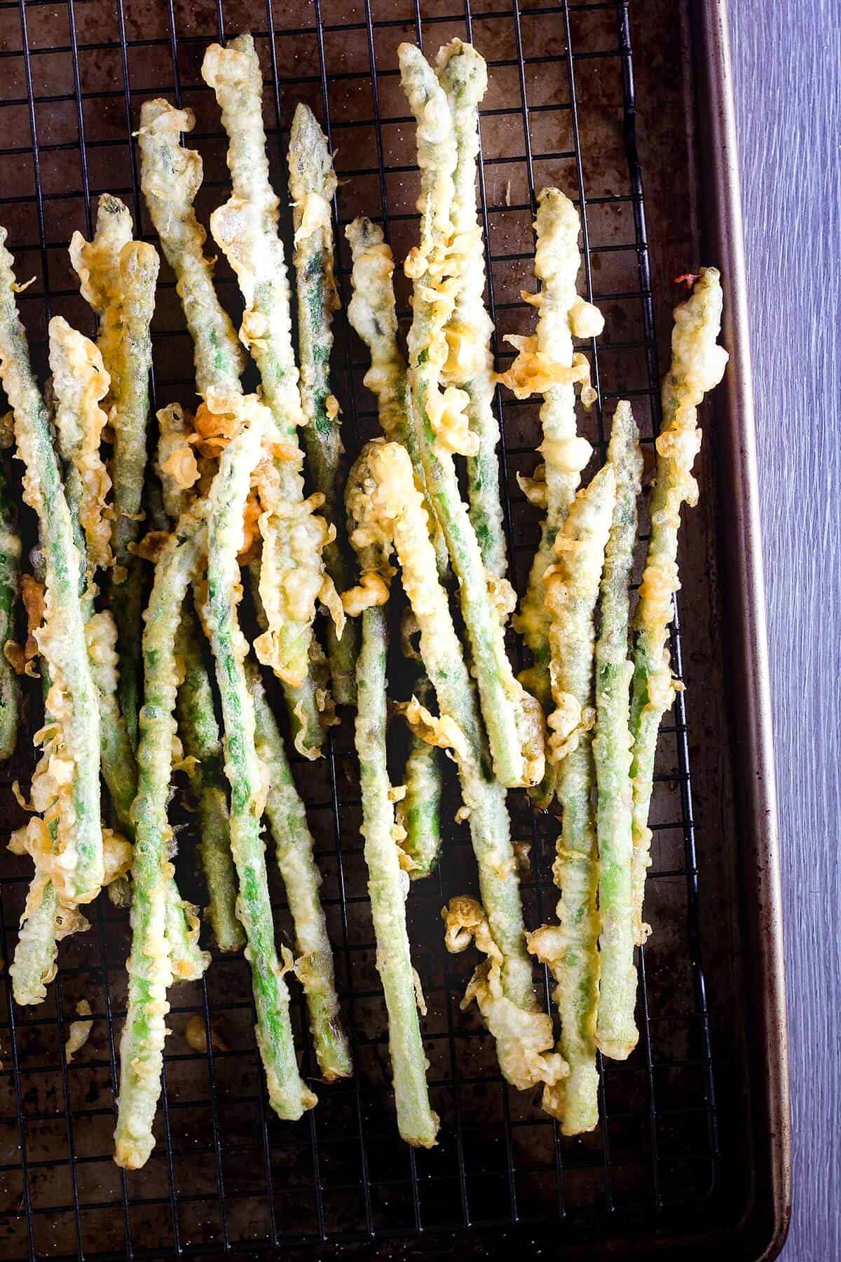 Asparagus tempura on sheet pan.