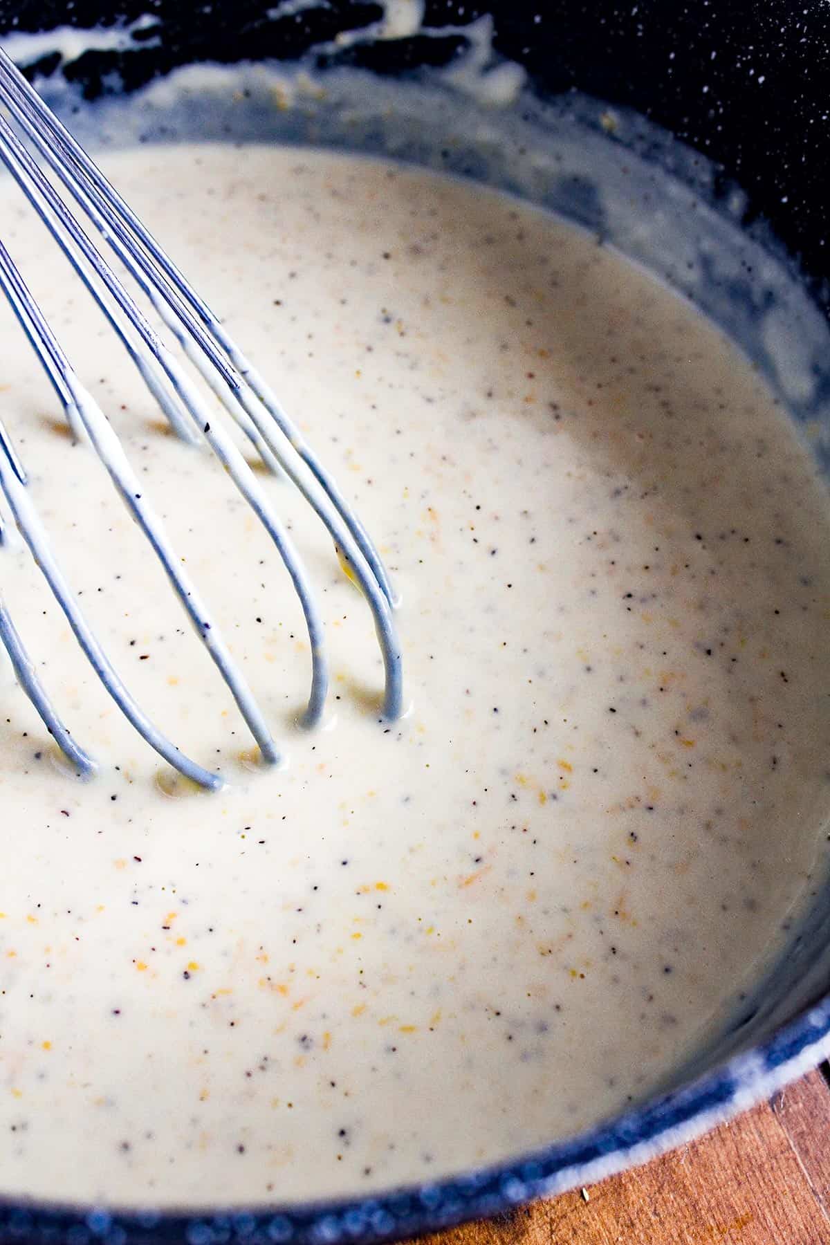 Cheese sauce with a whisk.