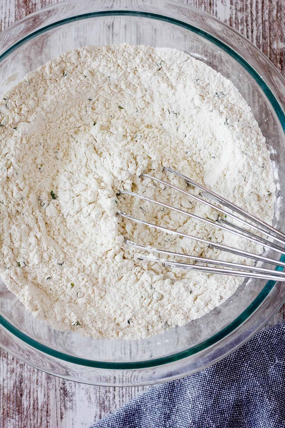 Combined dry ingredients in a bowl with a whisk.