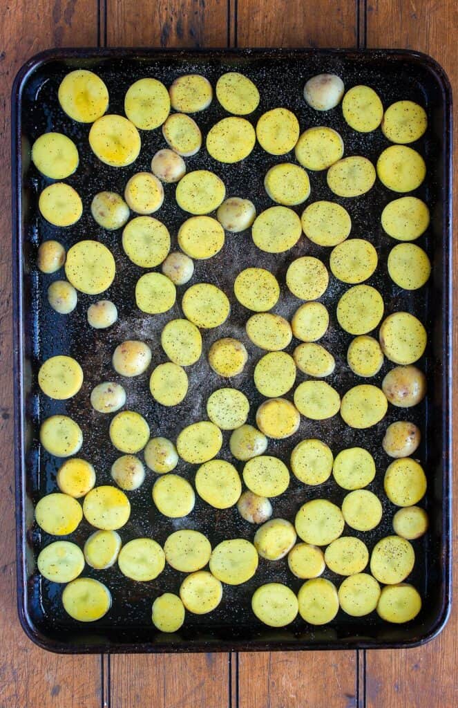 Sliced potatoes on baking sheet.