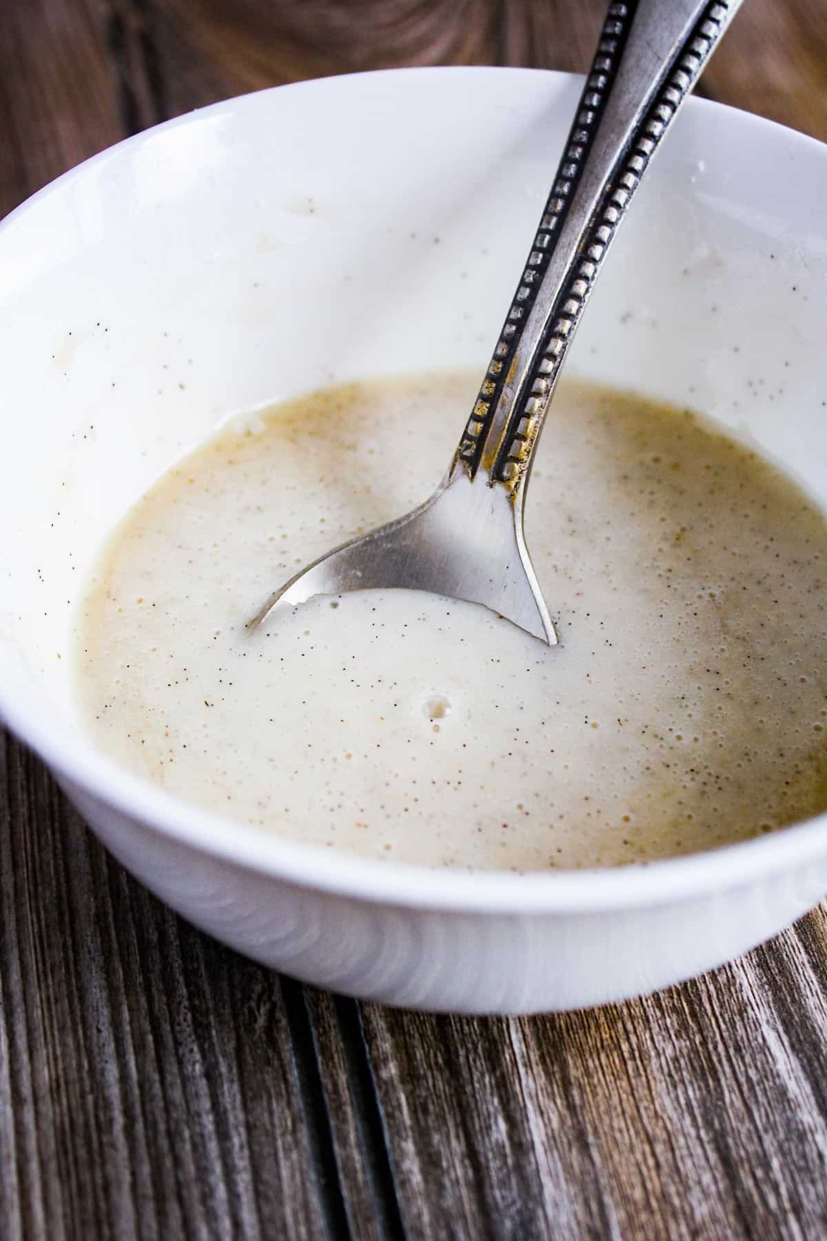Vanilla glaze with a spoon in a bowl.