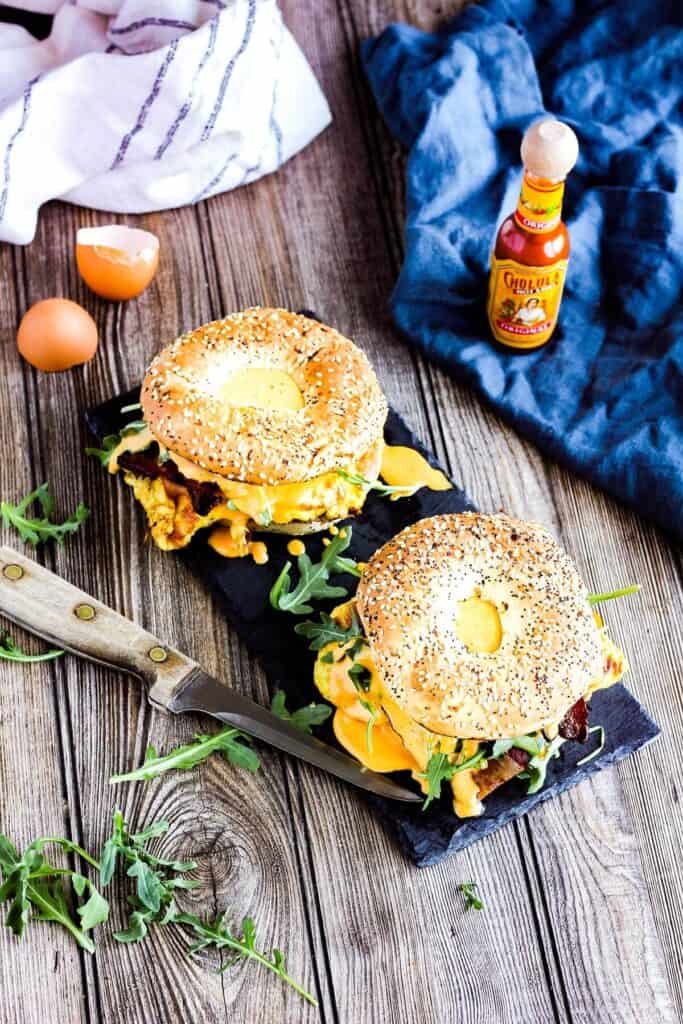 Two bagel breakfast sandwiches on a platter.