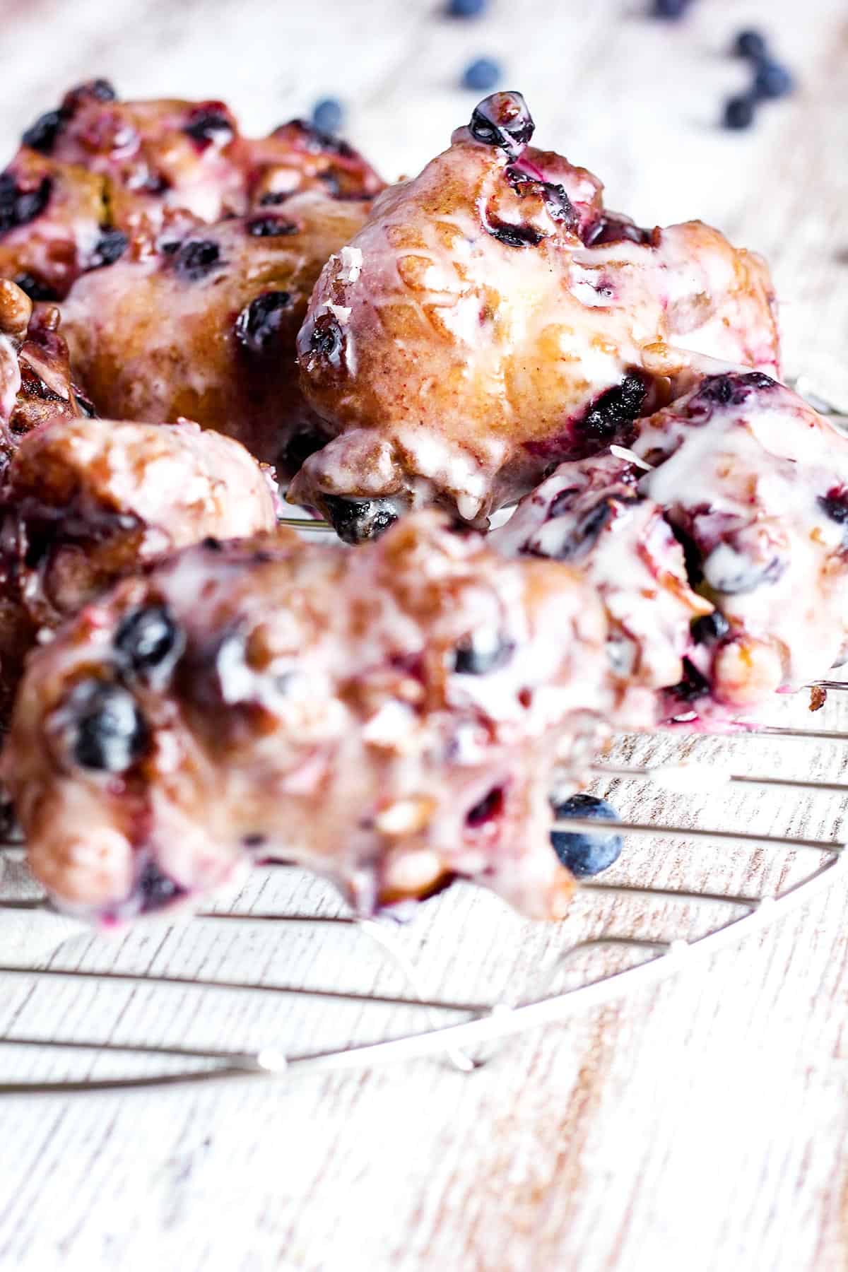 Close up of blueberry fritters with glaze.