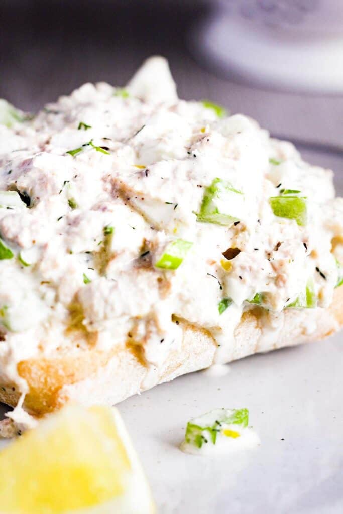 Close-up of lemon tuna salad with dill on a piece of bread.