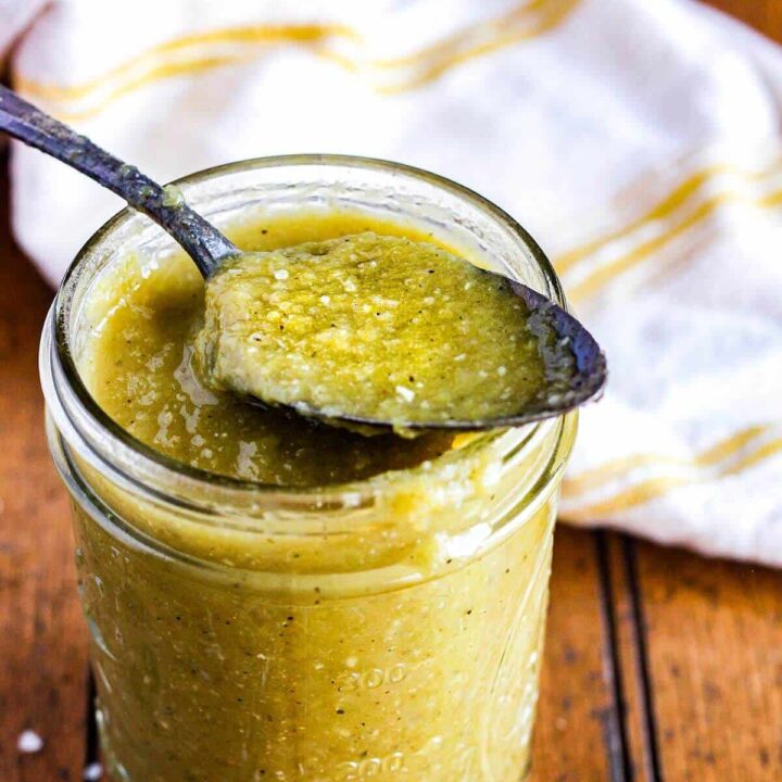 Spoonful of hatch chile enchilada sauce atop a jar.