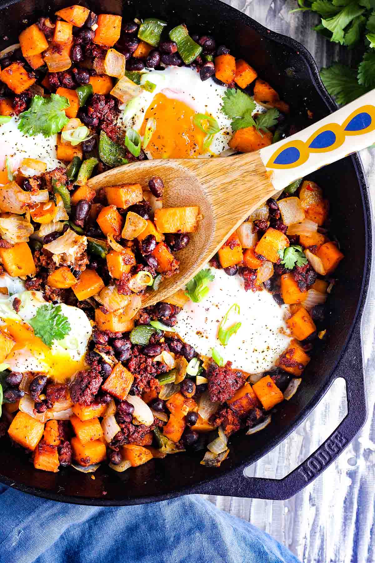 Sweet potato hash in skillet with serving spoon.