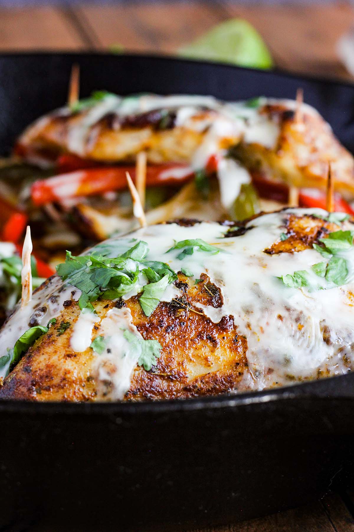 Close up of outside of fajita chicken breast smothered in cheese sauce.