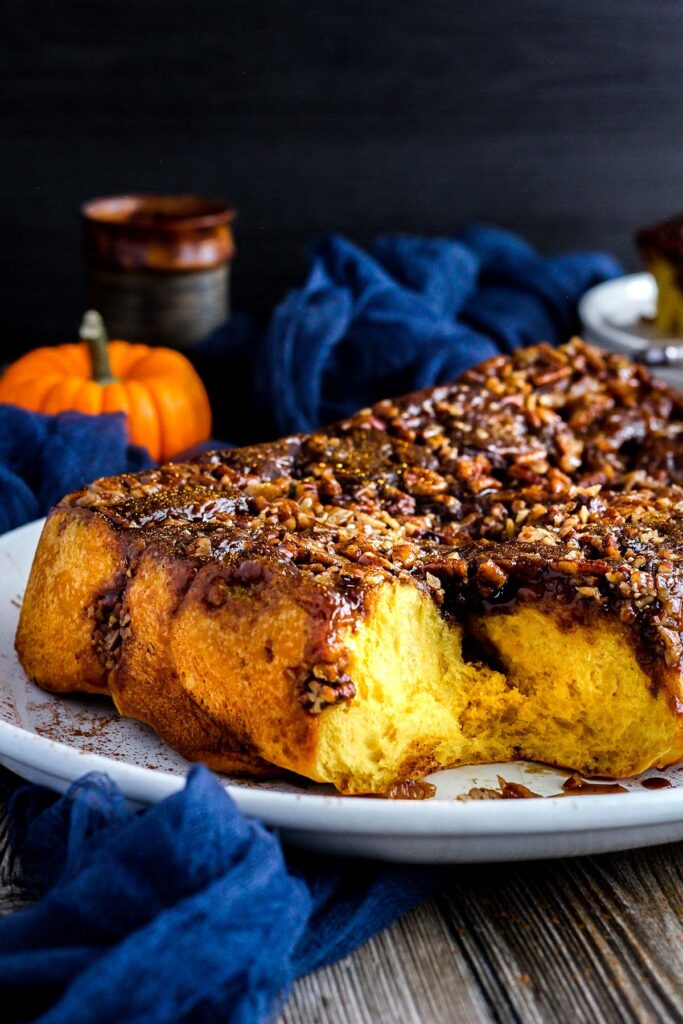 Close up of pumpkin pecan sticky rolls with fall decor.