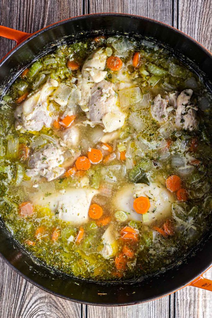 Braised chicken thighs in broth with vegetables.