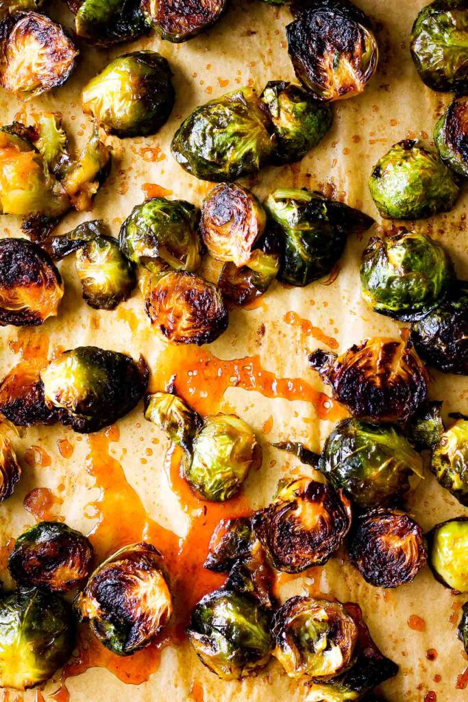 Sriracha honey Brussels sprouts in a pool of sauce.